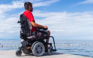 A man in a wheelchair enjoys the sea